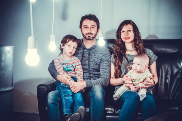 Family of four in a home on the couch parents and two sons