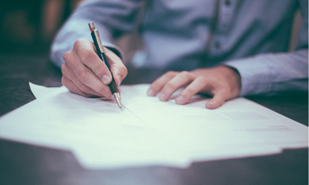 Hand of business person signing a paper