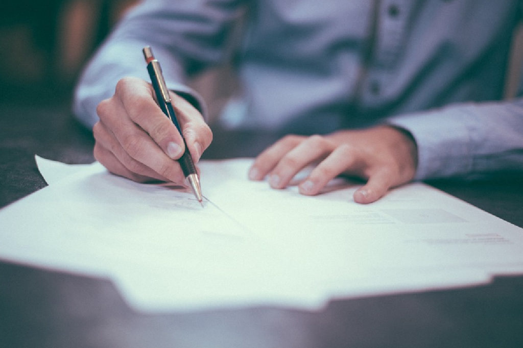 Hand of business person signing a paper