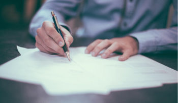 Hand of business person signing a paper