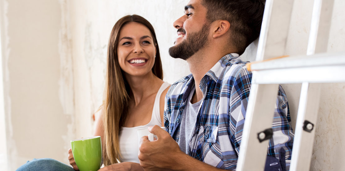 Couple sitting on the white wall of a brand new purchased home