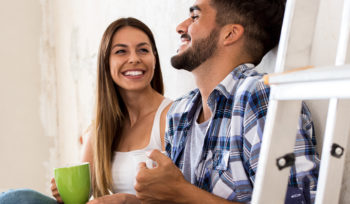 Couple sitting on the white wall of a brand new purchased home