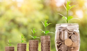 Small plants raising from stacks of coins