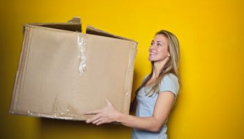 Blonde moving out carrying a big box