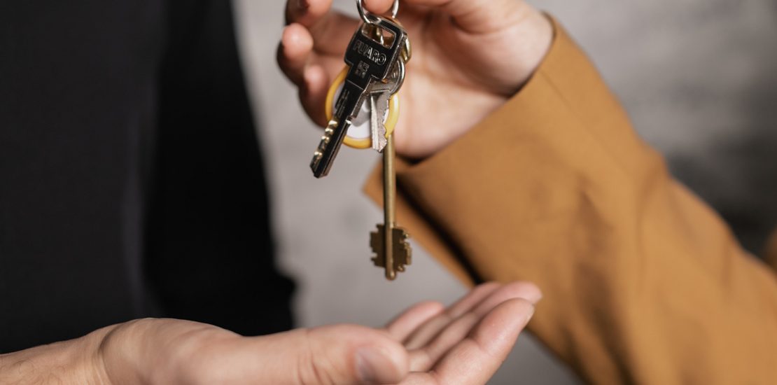 man giving property keys to woman hands close up