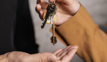 man giving property keys to woman hands close up