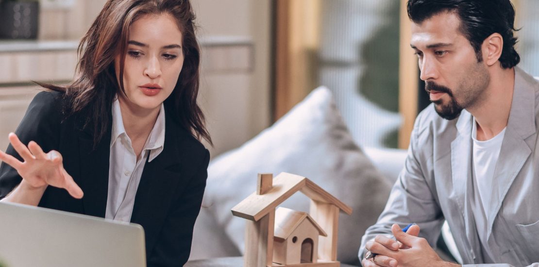 Buying property man discussing with woman in front of a laptop