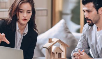 Buying property man discussing with woman in front of a laptop