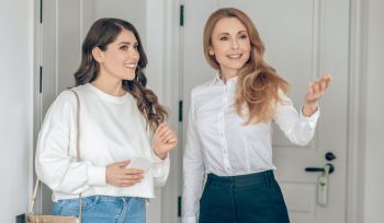 1 woman real estate agent shows house to another woman