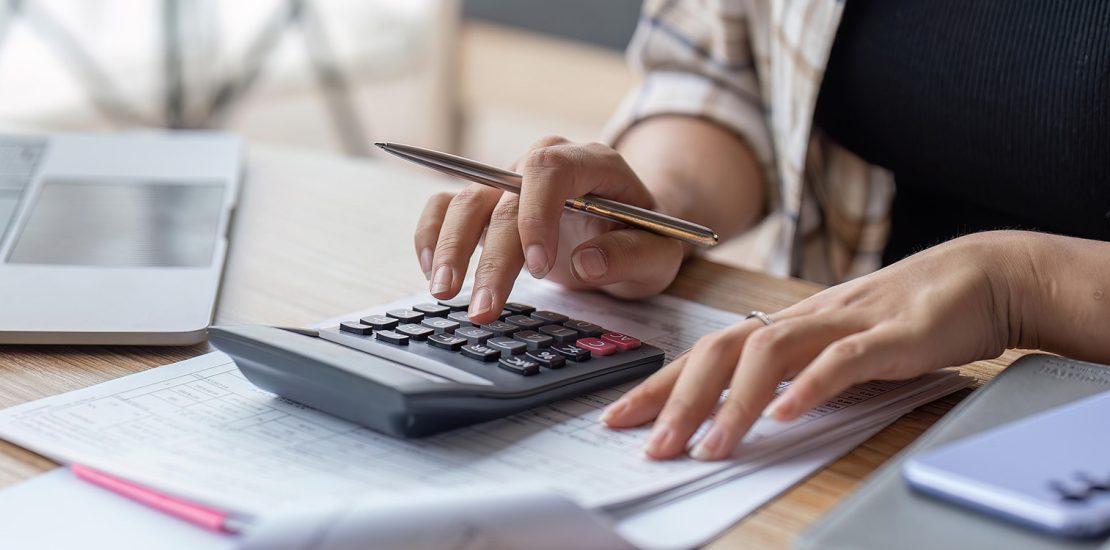 woman typing on calculator