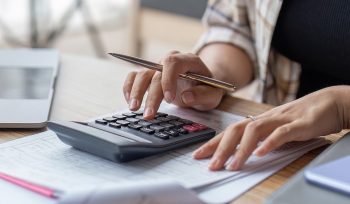 woman typing on calculator