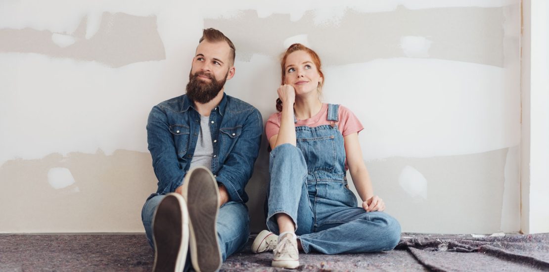 Couple sitting against a wall