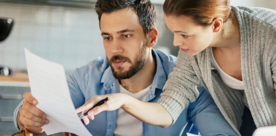 couple reading a paper bill