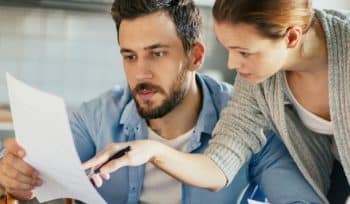 couple reading a paper bill