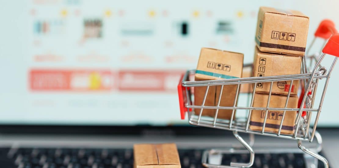 shopping cart in front of a laptop